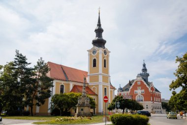 Hodonin, Güney Moravya, Çek Cumhuriyeti, 03 Temmuz 2021: St. Lawrence Barok Kilisesi ve belediye binası ana meydanında Nuremberg Sanat Nouveau tarzı kulesi, Nepomuk Aziz John heykeli.