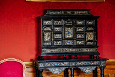 Valtice, Güney Moravya, Çek Cumhuriyeti, 04 Temmuz 2021: Barok ve Rönesans mobilyaları ile romantik kale iç mimarisi, sallanan kapılı büro, ahşap sekreter, mücevher depolamak için antika masa.