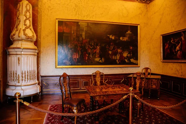 2021年7月4日チェコ共和国南モラヴィア バロック様式の木彫り家具のある城の内部 象眼細工のテーブルと椅子のある内閣 白いセラミックタイルのストーブ 金枠の絵 — ストック写真