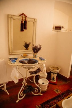 Jaromerice nad Rokytnou, Bohemya, Çek Cumhuriyeti, 06 Temmuz 2021: Barok ahşap oyma mobilyalar, banyo, ayna ve kurutulmuş lavanta buketleri ile beyaz ve mavi porselen lavabo.
