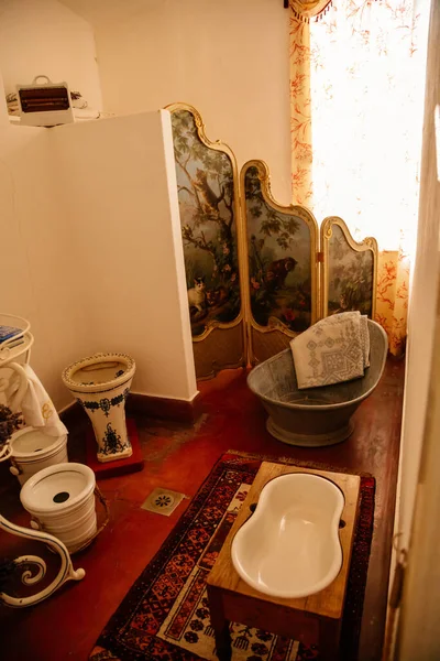 Jaromerice nad Rokytnou, Bohemya, Çek Cumhuriyeti, 06 Temmuz 2021: Barok ahşap oyma mobilyalar, banyo, ayna ve kurutulmuş lavanta buketleri ile beyaz ve mavi porselen lavabo.