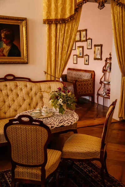 Jaromerice nad Rokytnou, Çek Cumhuriyeti, 06 Temmuz 2021: Barok ahşap oymalı mobilyalar, kanepe ve yumuşak koltuklar, masada porselen çay seti, yaldızlı çerçeveli tablolar.