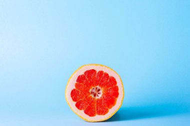 Mavi arka planda greyfurt. Diyet için egzotik meyve.