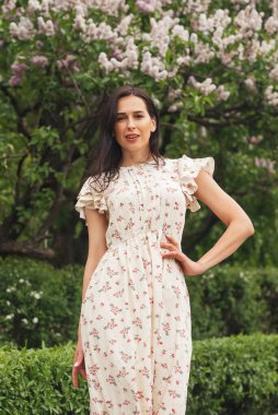 Şehir caddesinde poz veren zarif bir esmer kız. Şehrin arka planında şık giyinmiş güzel bir iş kadını..