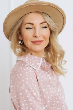 Uzun saçlı, çiçekli ve hasır şapkalı, uzun elbiseli, lüks ve genç bir kız. Hazırlanmak, sıcak bir yaz akşamında randevuya gitmektir.