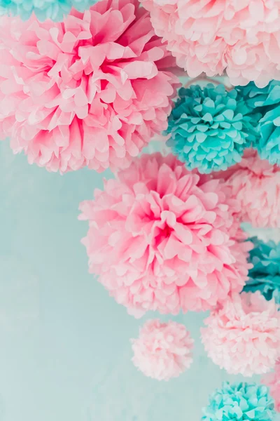 blue and pink pom-poms on background brick wall