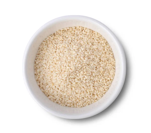 Beyaz arka planda izole edilmiş beyaz seramik kasedeki beyaz susam tohumları. Kameradan en üstteki görüntü