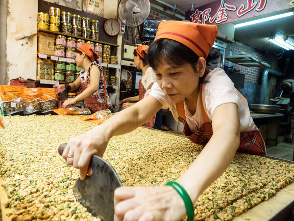 Уличный продавец стрижет арахисовые брикеты
