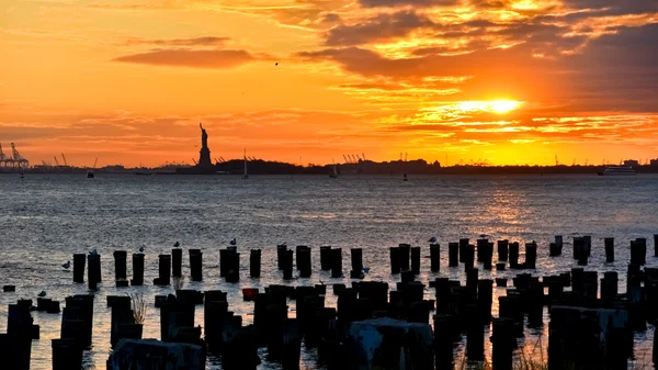 Estatua de la Libertad al atardecer en la ciudad de Nueva York . Imágenes de stock libres de derechos