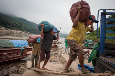 Laotian porters on the Mekong River clipart