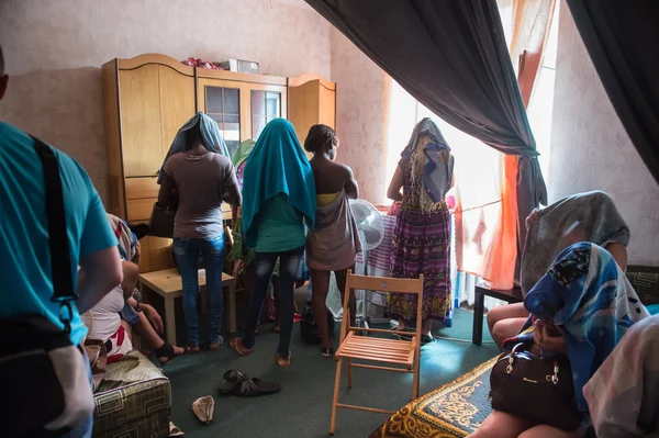 Kadınlar, karışanları tespit etmek için şehrin genelevlerine yapılan polis baskınısırasında, kafasına sarılı havlularla yüzlerini saklıyorlar..