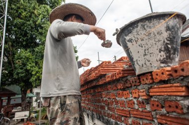 A man builds a wall of bricks