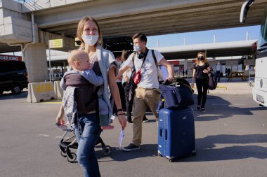 Antalya, Türkiye - 13 Kasım 2020: Koruyucu maskeler takan insanlar salgın sırasında Akdeniz tatil beldesine geldiler. Havaalanının önündeki meydan.