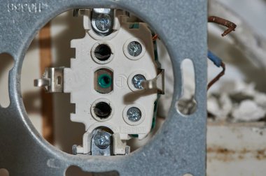 Eski bir ev evi konvansiyonel üç aşamalı elektrik prizi. Duvarında fayanslar ve yenileme çalışmaları var.