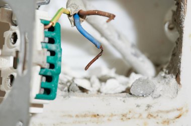 Eski bir ev evi konvansiyonel üç aşamalı elektrik prizi. Duvarında fayanslar ve yenileme çalışmaları var.