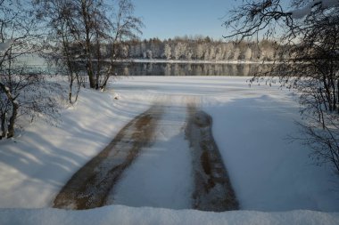 Kış manzarası: Burnaya nehri Ladoga Gölü 'ne akar, ağaçlar kırağı kaplar, panoramik manzara.