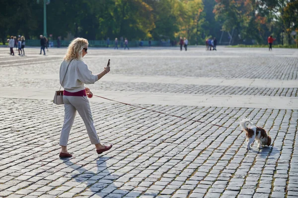 Młoda Blondynka Lekkich Ubraniach Spaceruje Psem Cavalier King Charles Spaniel — Zdjęcie stockowe