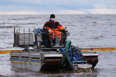 St. Petersburg, Rusya - 24 Ekim 2020: Finlandiya körfezinde sular çekildikten sonra temizlenen çevre hizmetleri çalışanları çöpleri, petrol sızıntılarını, mekanik yollarla zararlı maddeleri temizliyor