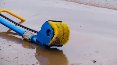 Otomatik çöp, çamur, su ve kıyı şeridinden dökülen petrol ürünleri, su ve su rezervlerinin arka planına karşı beyaz fırçalar için bir cihaz.