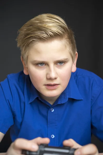 Serious male child in blue using game controller — Stock Photo, Image