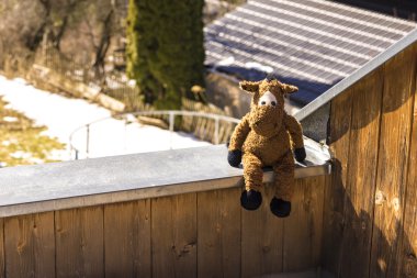 Kabin duvarda oturan sevimli peluş oyuncak