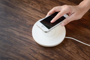 cep telefonu modern cihazı, kablosuz bir şarj cihazı koyarak Yardım