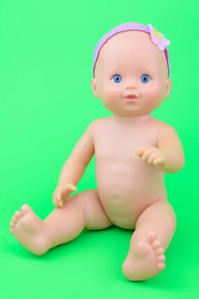 Nagi baby doll siedzącej pozie, izolat tło zielony — Zdjęcie stockowe