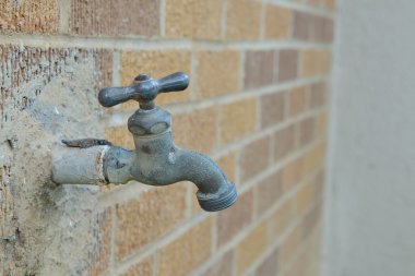 tuğla duvarına bitişik musluk