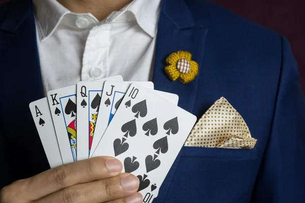 Homem segurando cartão real straight flush — Fotografia de Stock