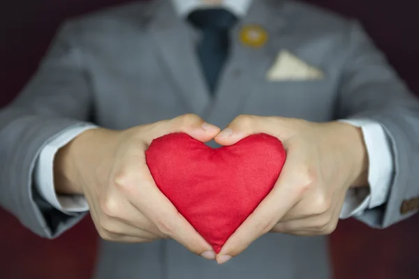 Sevgililer günü kavramı, adam kırmızı kalp taşır.