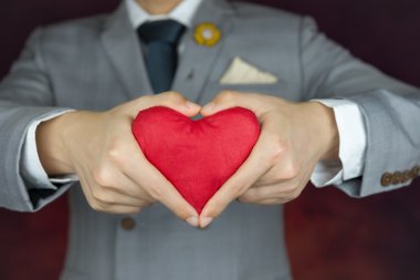 Sevgililer günü kavramı, adam kırmızı kalp taşır.
