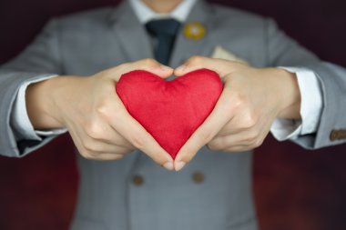 Sevgililer günü kavramı, adam kırmızı kalp taşır.