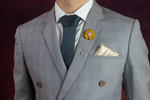 Сірий костюм простої текстури, краватка, брошка, носовичок — стокове фото