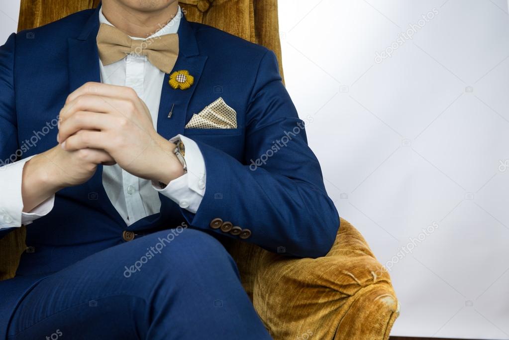 man blue suit sitting on cozy sofa