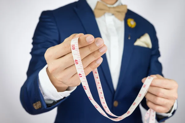 Man in blue suit bowtie, brooch, pocket square blue suit carry m — Stock Photo, Image