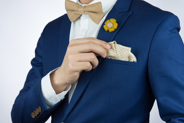 man blue suit bowtie, brooch, pocket square