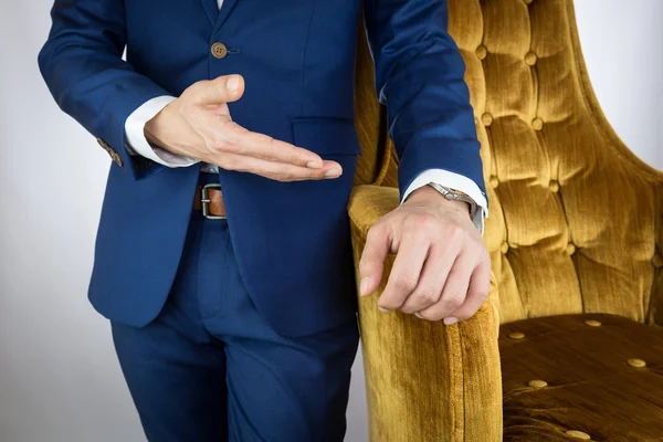 Uomo in abito blu in piedi accanto al divano — Foto Stock