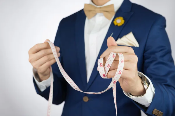 Man in blue suit bowtie, brooch, pocket square blue suit carry m — Stock Photo, Image