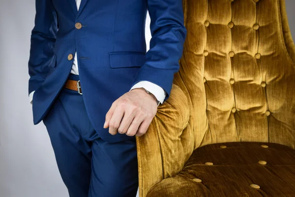 Homem de terno azul em pé ao lado do sofá — Fotografia de Stock