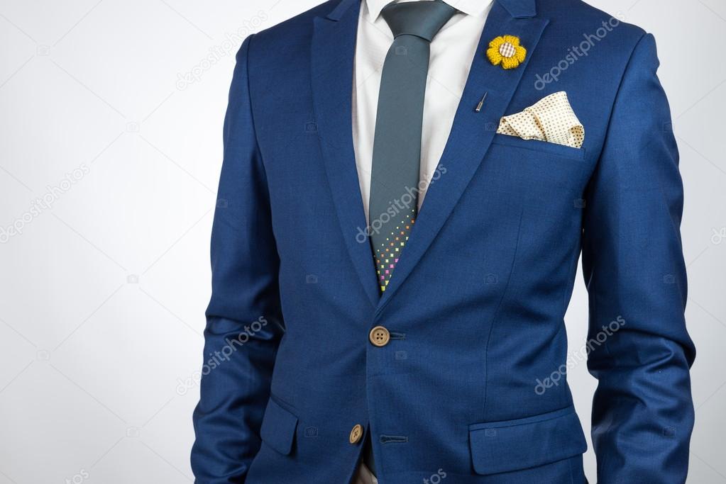 man blue suit necktie, brooch, pocket square