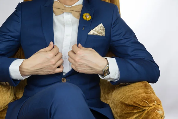 Traje azul hombre sentado en un sofá acogedor —  Fotos de Stock