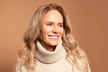 Zarif özellikleri, gösteriş tarzı, cazibesi ve doğal güzelliği olan, sofistike ve kendine güvenen bir ifadeyle bej bir kazak giyen çekici, son sınıf öğrencisi bir kadının yakın çekimi..