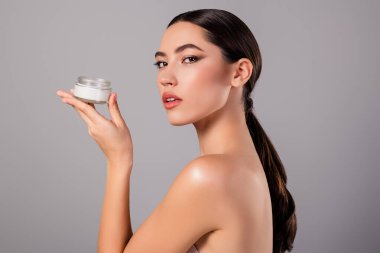 Cilt bakımı yapan zarif genç bir kadın, özgüven yayıyor, güzellik, özgüven ve zarafeti temsil ediyor..