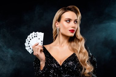Göz kamaştırıcı siyah pullu bir elbise giymiş çekici bir kadın zarif poz veriyor, elinde kendine güvenen ve büyüleyici bakışlı bir poker fanı tutuyor. Moda ve kumarhane temaları için mükemmel.