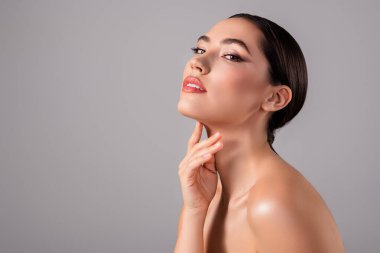 Pürüzsüz esmer saçlı, mükemmel ciltli, kendine güveni ve zarafeti olan güzel bir bayan. Etkileyici bir portre. Tarafsız arka planda modern güzellik ve stil sergiliyor. Çekici özelliklerini çerçeveliyor..