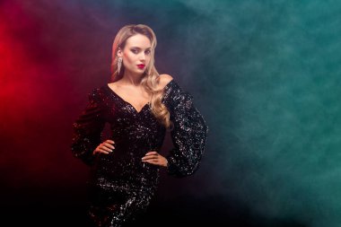 Işıl ışıl siyah elbiseli, ışıl ışıl aydınlatma altında kendine güveni ve güzelliği olan, moda, güzellik ve şenlik teması için ideal bir kadın..