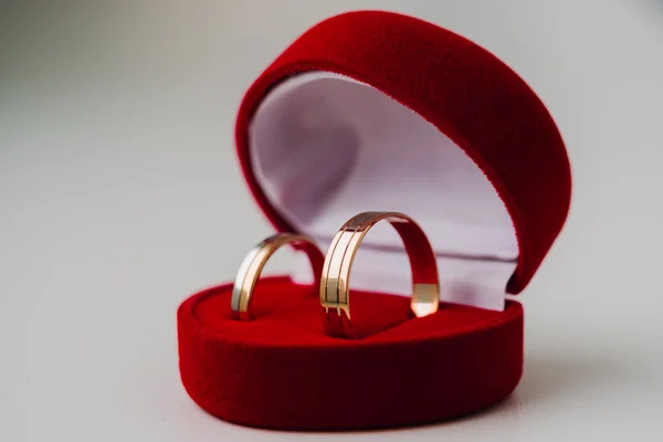 Gouden trouwringen in rood vak de vorm van een hart — Stockfoto