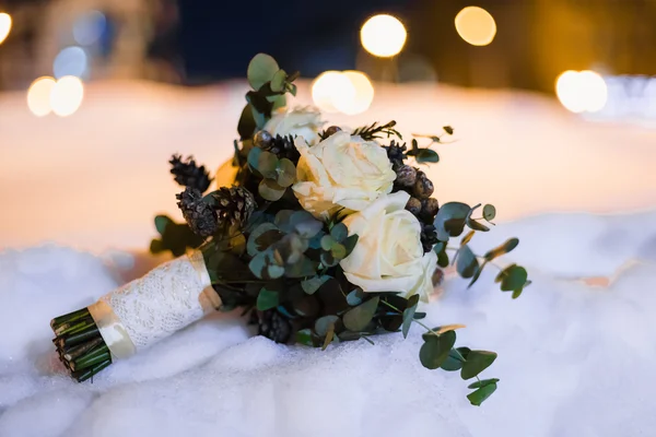 Ramo de boda de rosas blancas y conos en la nieve —  Fotos de Stock
