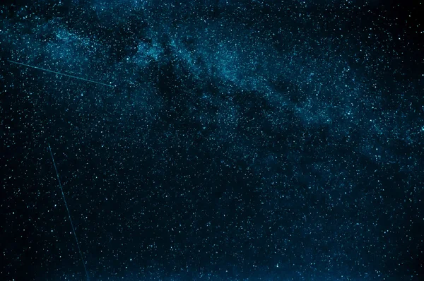 Vía láctea y estrellas fugaces sobre un fondo de cielo azul — Foto de Stock