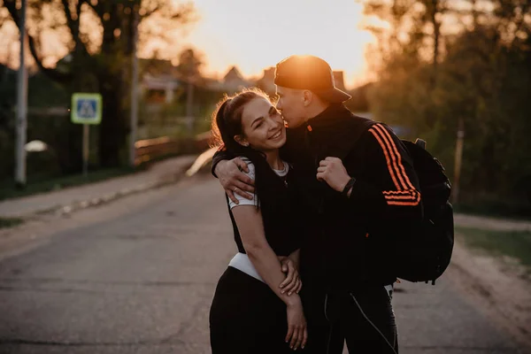 Couple amoureux un homme et une fille baiser par la route au coucher du soleil en été — Photo